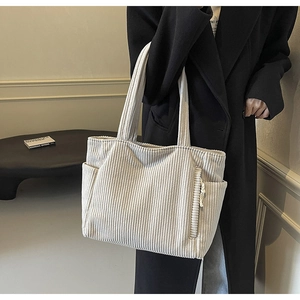 Dettaglio della borsa tote in velluto a coste con texture verticale e tasca laterale