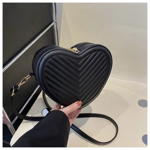 Vue détaillée du sac en forme de cœur avec surpiqûres en V noires et finitions dorées