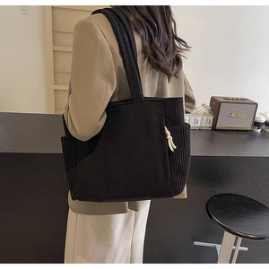 Dettaglio borsa tote in velluto a coste nero con tasca laterale e corda intrecciata zip