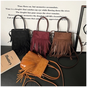 Close-up of bohemian tassel handbags in four colors with suede texture and shoulder straps