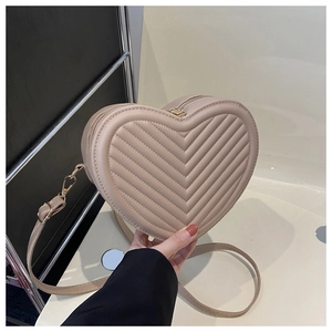 Détail du sac à bandoulière en forme de cœur avec matelassage en V et détails dorés