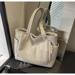 Dettaglio della borsa tote in velluto a coste con tasche laterali e trama fine