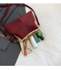 Vue intérieure montrant la grande capacité du sac coquille en daim rétro avec fermoir doré
