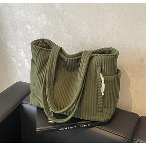 Dettaglio borsa tote in velluto a coste verde oliva con tasca laterale e tracolla larga