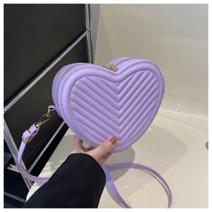 Détail du sac bandoulière violet en forme de cœur avec matelassage chevron et métal doré