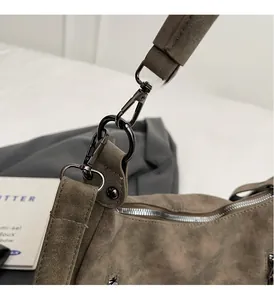 Close-up of premium dark taupe suede tote bag with durable dark gray metal hardware and strap
