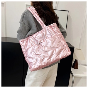 Détail du cabas matelassé rose avec finition métallique brillante et texture gonflée