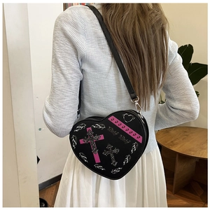 Détail du sac à bandoulière en forme de cœur avec croix rose et clous cœur argentés
