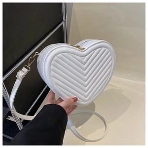 Détail du sac coeur blanc en cuir PU avec matelassage en V et ferrures métalliques dorées