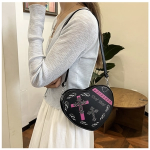 Détail du sac à bandoulière en forme de cœur avec croix rose et imprimé Baby Baby