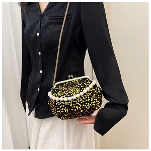 Détail de pochette de soirée avec paillettes dorées et bande de perles élégante