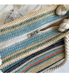 Détail de la fermeture éclair en métal et des rayures en paille tisseé du sac fourre-tout