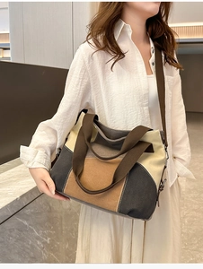 Detailed shot of a color-block canvas tote bag with adjustable brown shoulder strap
