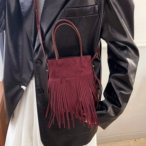 Ethnic burgundy suede tassel handbag with crossbody strap shown on a model