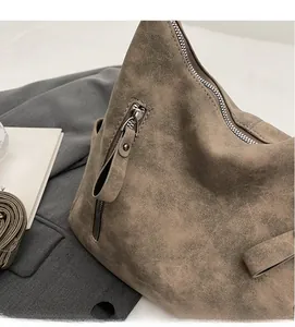 Detail of soft matte leather tote bag featuring a smooth metal zipper and side pocket