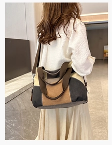 Close-up of the large color-block canvas tote bag worn by a model in a casual setting