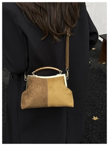 Détail d'un sac coquille vintage en daim bicolore avec poignée en bois élégante