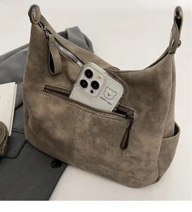 Macro view of a large capacity crossbody bag showing functional pockets and zipper details