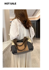 Detail of color-block canvas tote bag with brown straps and detachable shoulder strap