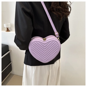 Détail du sac bandoulière cœur violet clair avec surpiqûres en V et fermeture éclair dorée