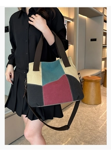 Close-up of color-block canvas tote bag showing textured panels and adjustable shoulder strap
