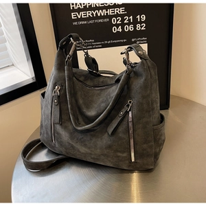 Detail of dark grey suede tote bag with metal zipper accents and removable shoulder strap