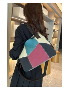 Lifestyle shot of woman wearing a large color-block canvas tote bag in a library setting