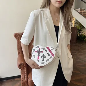 Sac à main blanc en forme de cœur avec imprimé gothique et texte Baby Baby sur un modèle