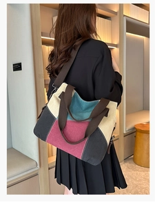 Detail of color-block canvas tote bag with contrast stitching and wide fabric strap