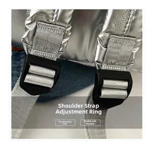 Détail de la boucle de réglage noire mate et de la sangle tissée argentée sur le sac à dos
