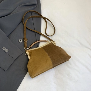 Détail d'un sac coquille vintage en daim mat avec contraste de couleurs et cadre doré