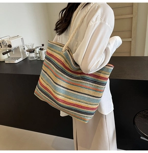 Détail du sac cabas tissé à rayures colorées avec poignées en corde blanche et œillets