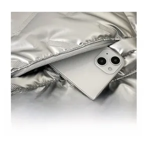 Détail de la poche zippée cachée sur sac à dos argenté contenant un smartphone moderne