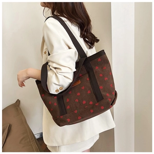 Brown corduroy tote bag with strawberry print shown on model for size perspective