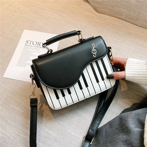 Fashionable black and white piano key crossbody saddle bag with gold treble clef detail