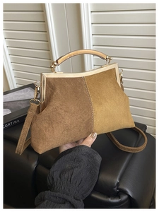 Détail du sac à main en daim caramel avec poignées ambre et fermoir en métal chic