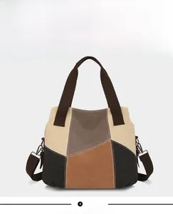 Front view of geometric patchwork canvas tote bag with brown straps and nylon texture
