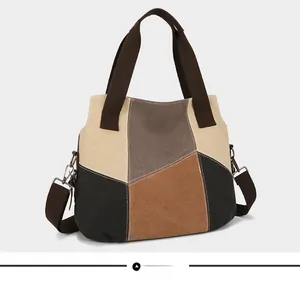 Side view showing the color-block canvas patchwork and wide fabric handles of the tote bag