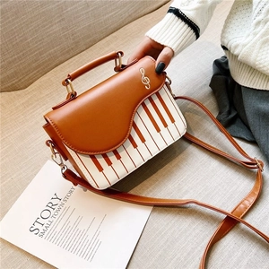 Women's vintage piano pattern saddle bag with gold music note buckle in brown and white