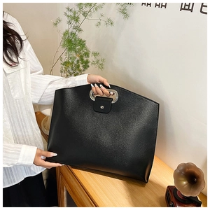 Detail of elegant black PU laptop briefcase with silver oval handle and snap flap closure