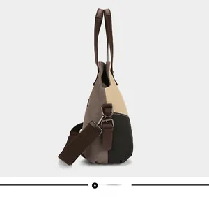 Detail view of canvas tote bag featuring side metal buckles and adjustable brown strap
