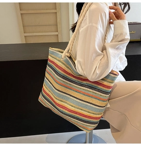 Gros plan sur le sac fourre-tout tissé à rayures colorées avec anses en corde blanche