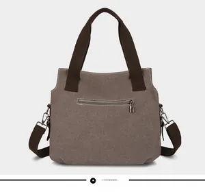 Detail view of canvas tote bag back with metal zipper pocket and detachable strap