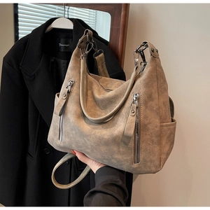 Detail of vintage brown leather tote bag with vertical zippers and side pockets