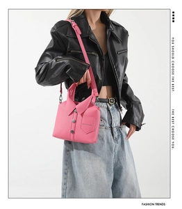 Detailed view of pink shirt-shaped handbag with buttons and collar on a fashion model