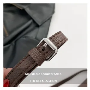 Close-up of adjustable brown leather shoulder strap with silver buckle and pebbled texture