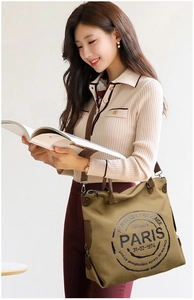 Close-up of khaki canvas tote with Paris stamp design and adjustable woven strap