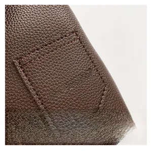 Detail of brown litchi grain leather texture with silver FASHION & BAGS lettering