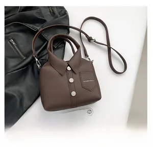 Detail of shirt-style dark brown lychee leather bag with collar and button design