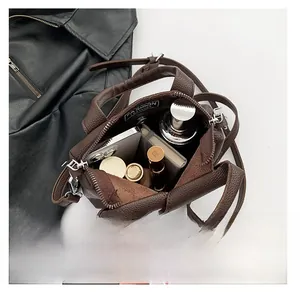 Interior view of brown lychee grain leather bag showing capacity for phone and cosmetics